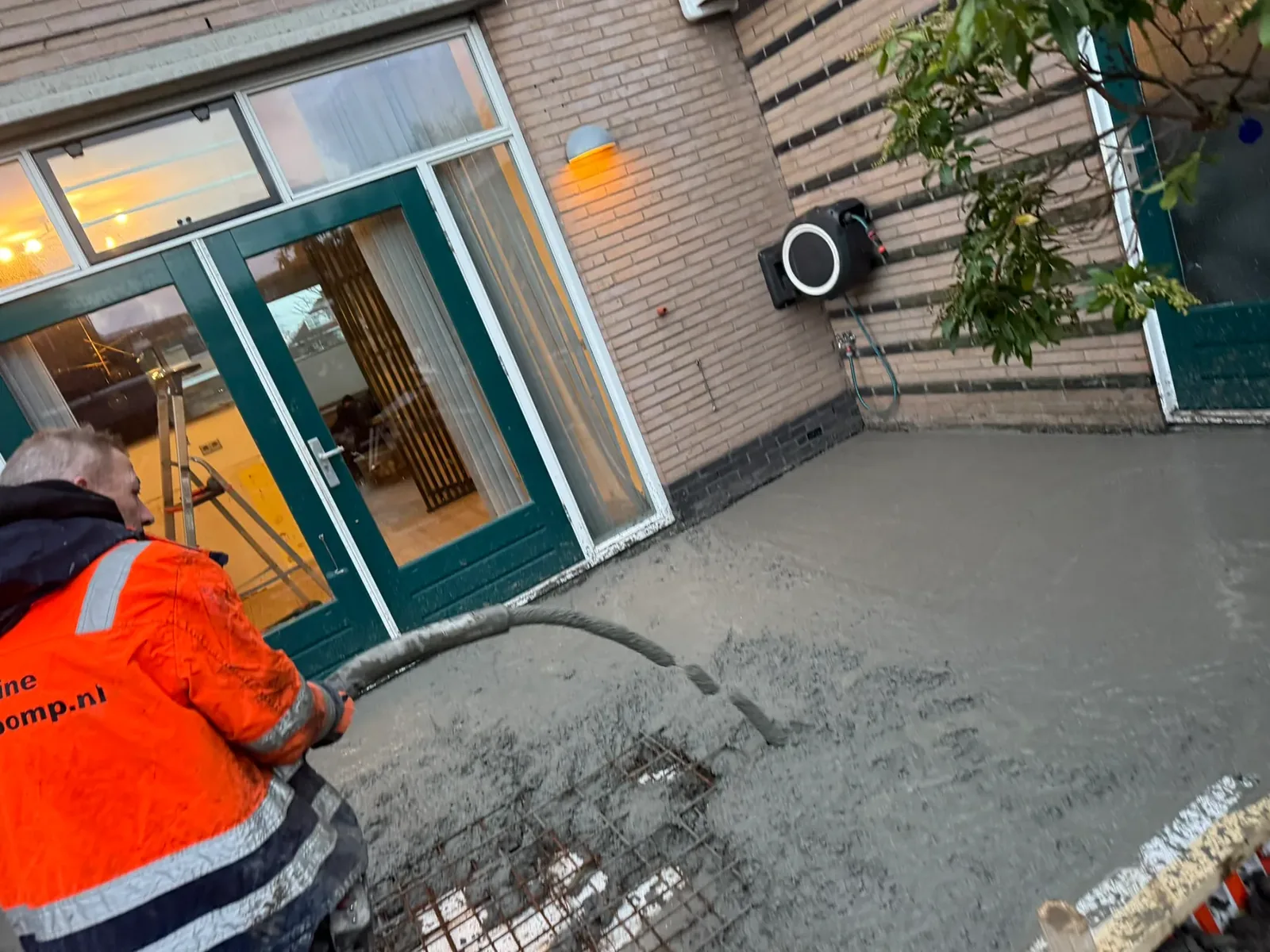 De betonvloer wordt met een betonpomp gestort.