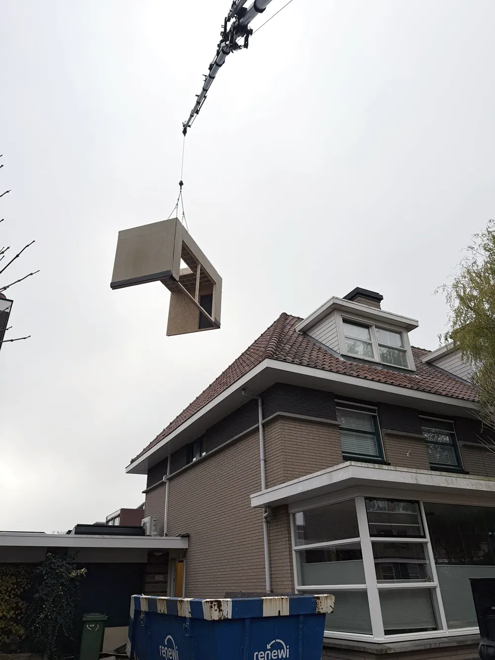 Het tweede element hangt aan de kraan, over het dak heen.