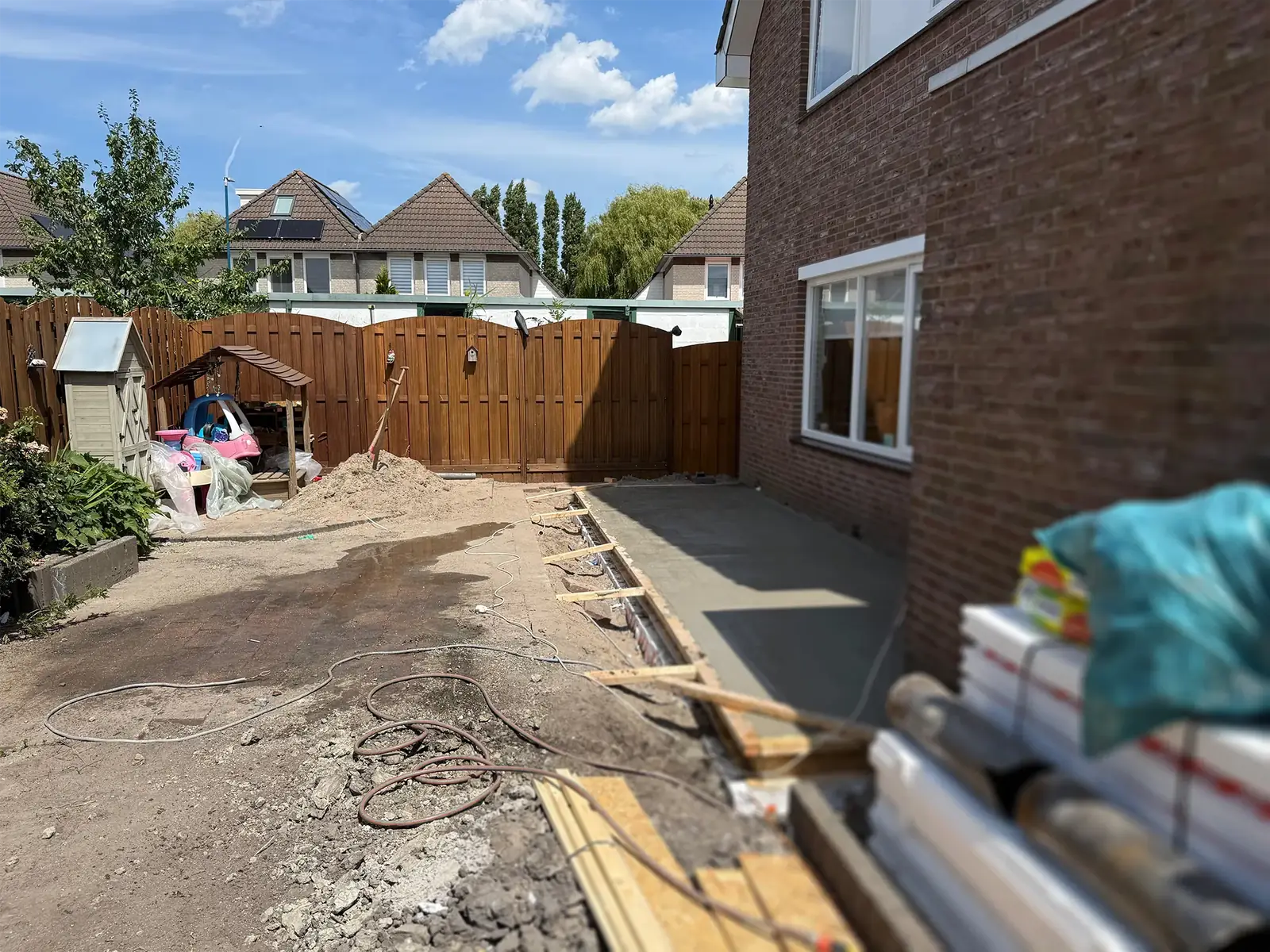 De gestorte betonvloer ligt langs de achtergevel, de bekisting is er nog.