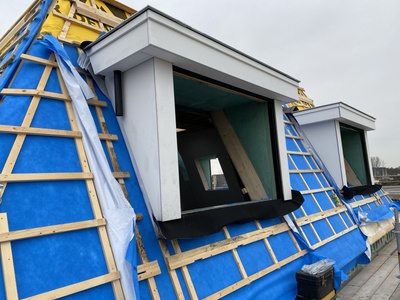 De dakkapellen tijdens de bouw: folie en tengels op het dakvlak, de kozijnopeningen nog open.
