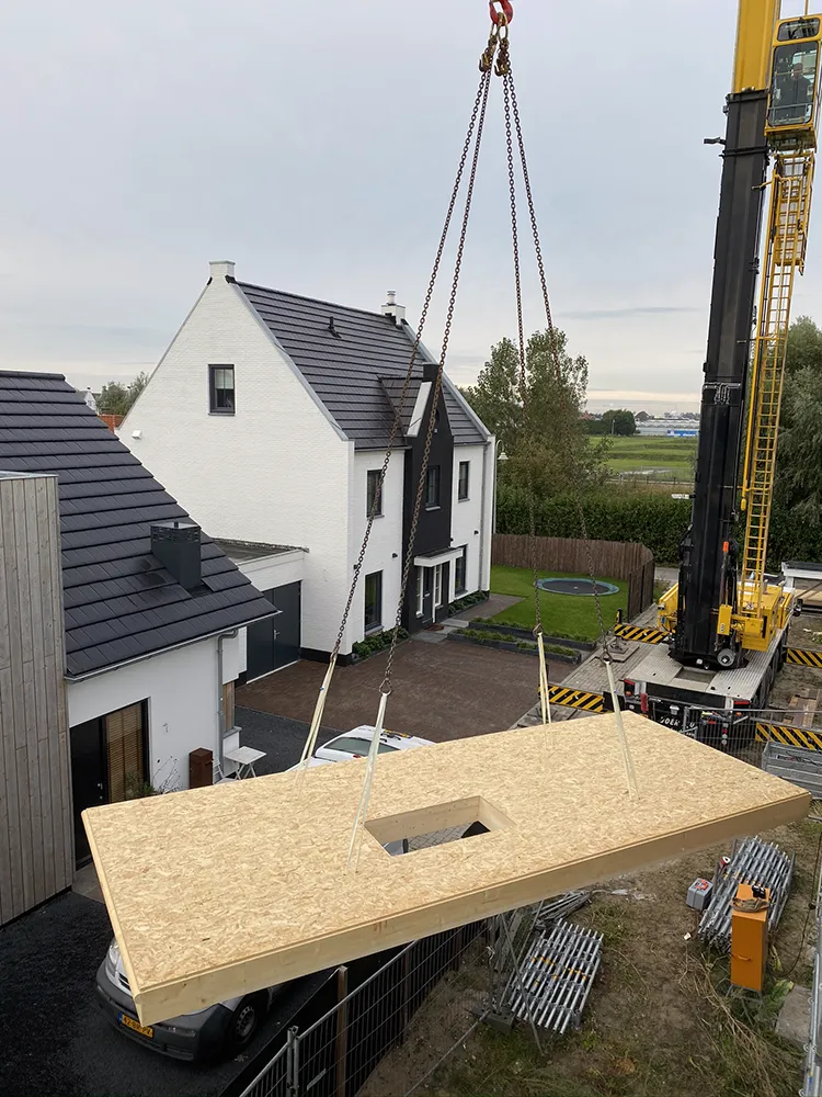 Een vloerelement met een sparing hangt aan de mobiele kraan.